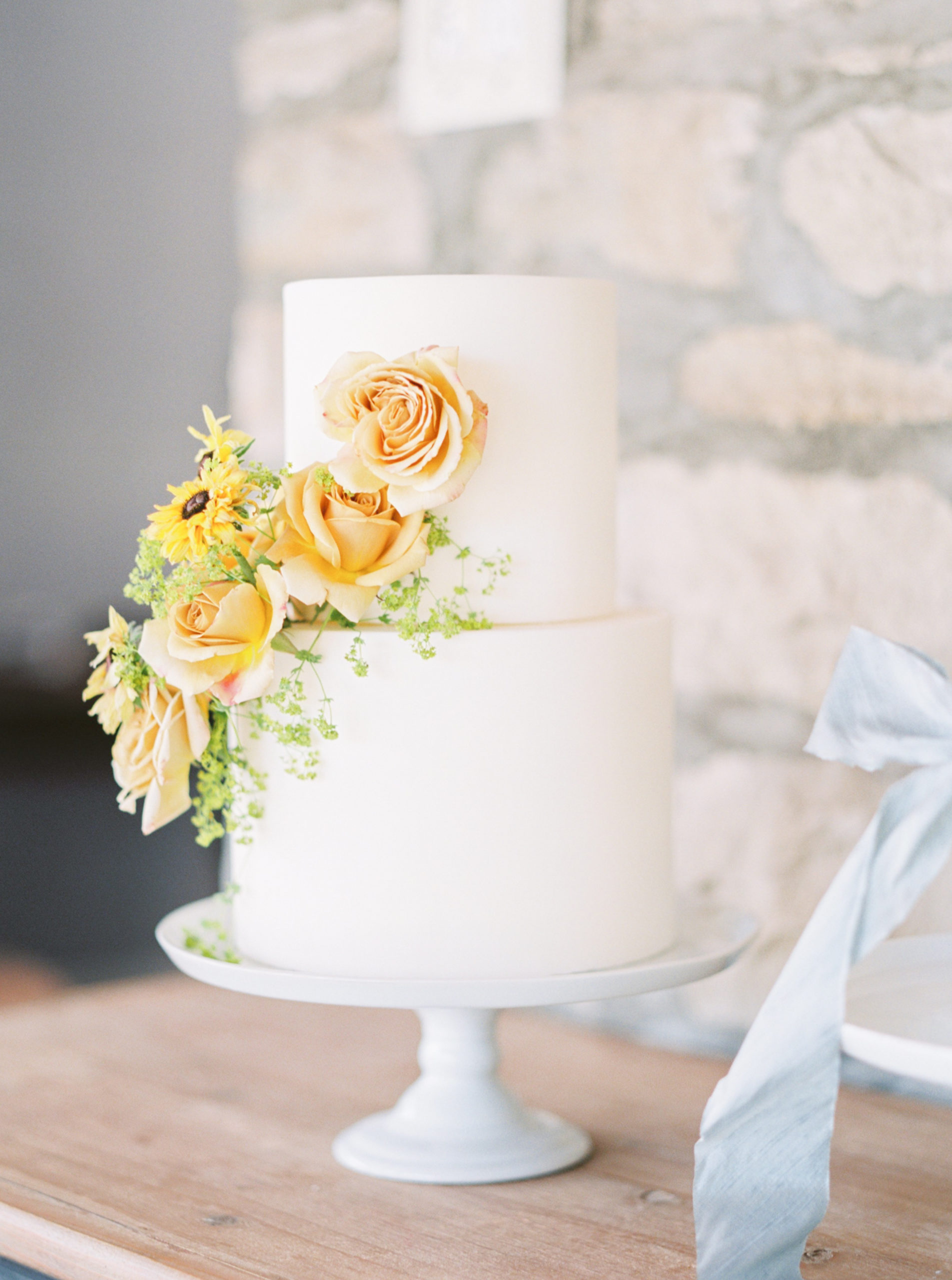 all white cake with orange and yellow flowers